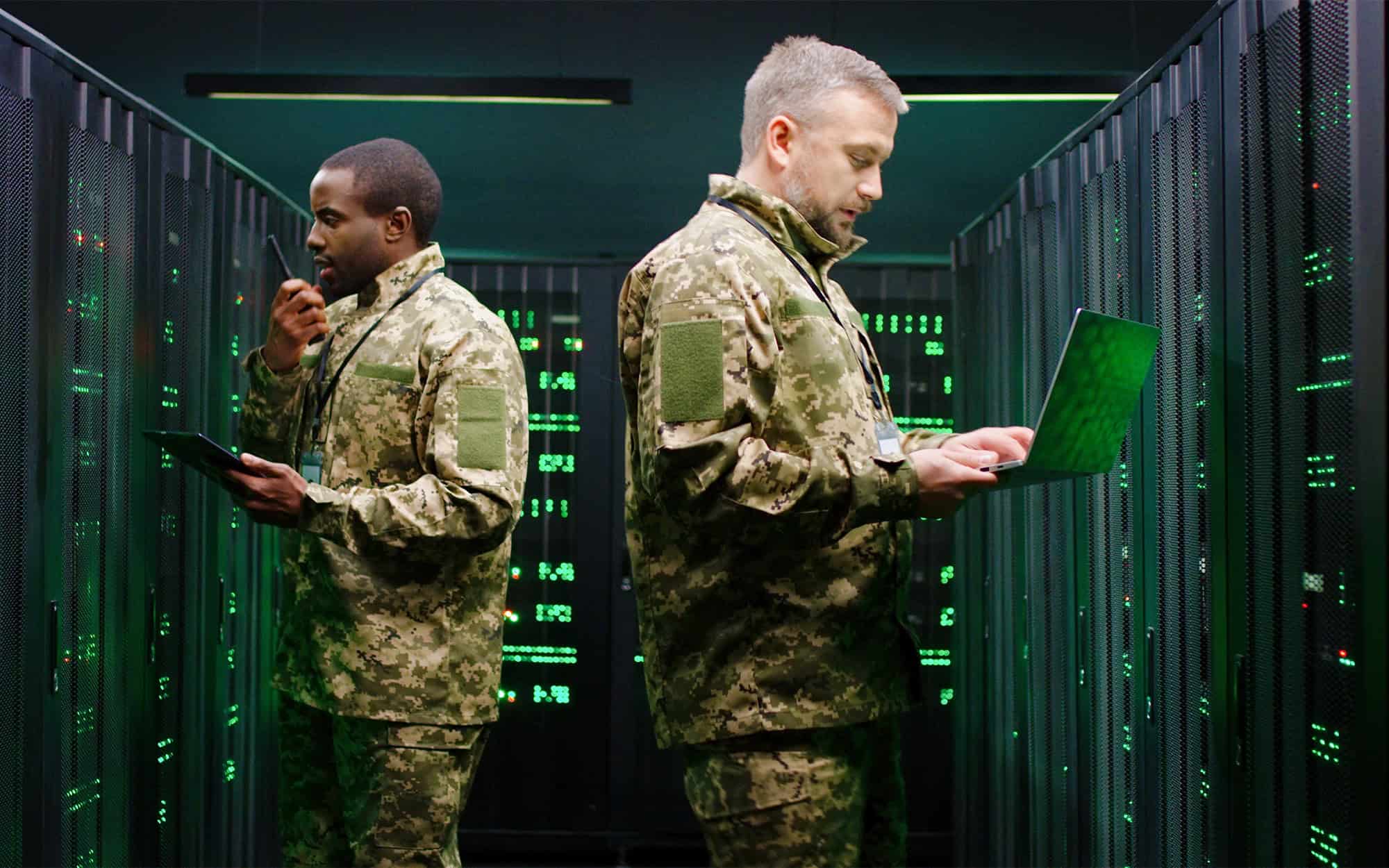 Military Personnel Using Laptops in Server Room
