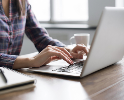 Woman hands typing on computer keyboard closeup