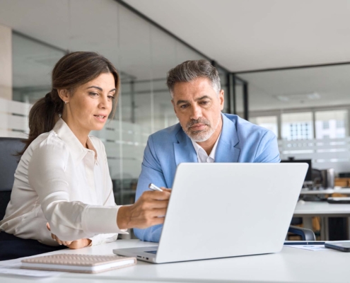 Two business workers looking at laptop